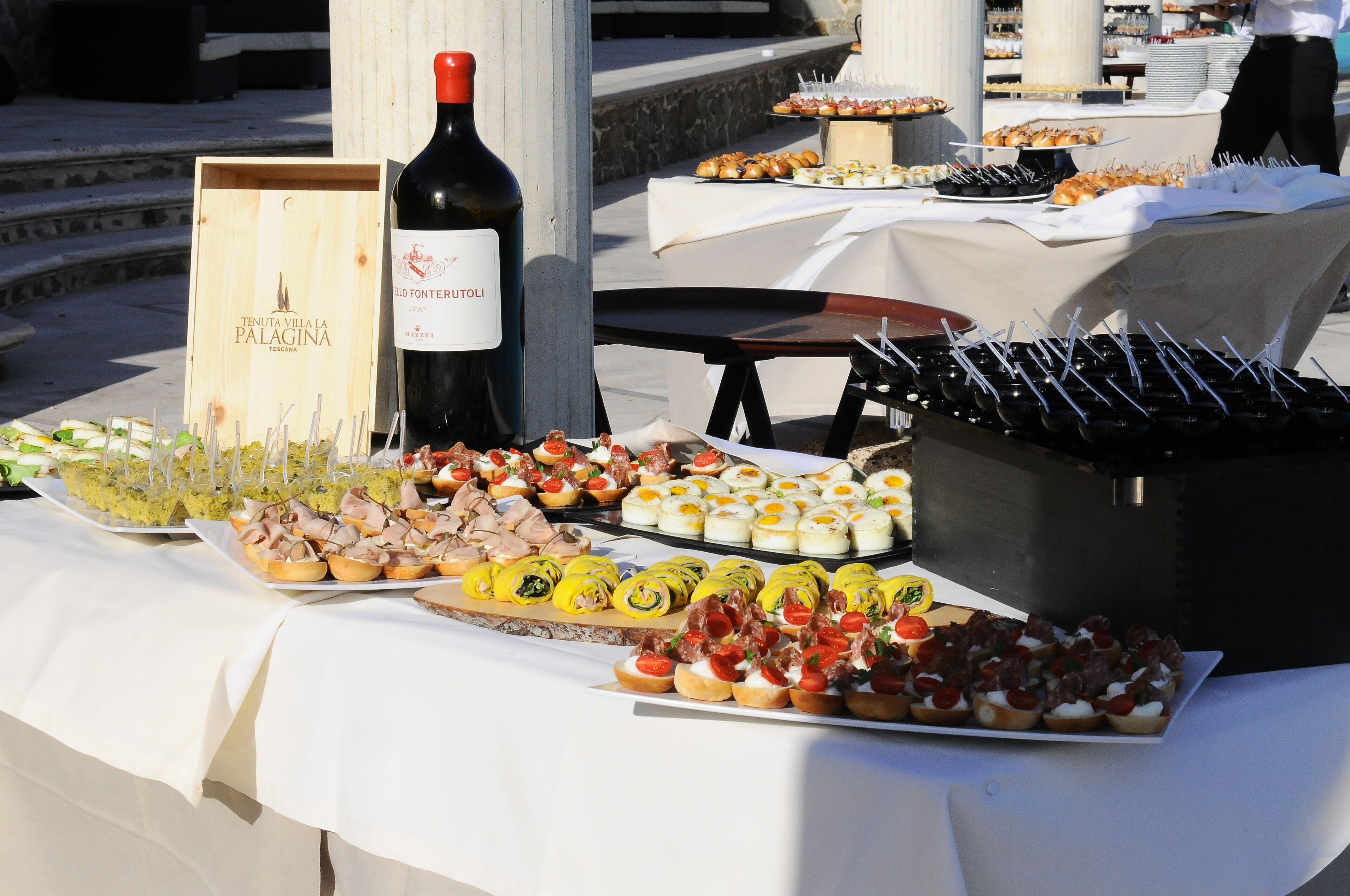 Une table de buffet avec divers plats et une bouteille de vin.