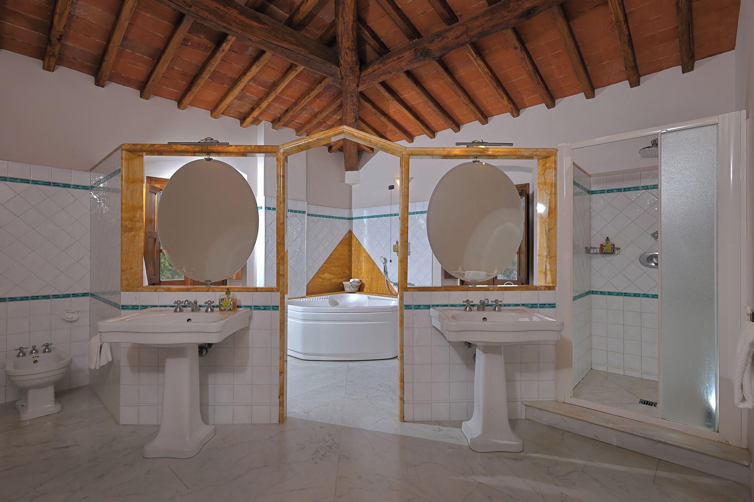 Ein Badezimmer mit zwei Waschbecken, einer Badewanne und einer Dusche.
