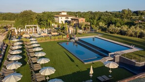 A resort with a large swimming pool, sun loungers, and umbrellas. - Palagina la cascina (Figline e Incisa Valdarno)