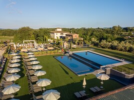 Un resort con una amplia piscina, tumbonas y sombrillas.