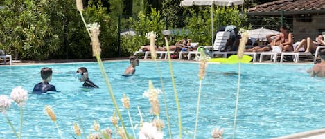 En säsongsöppen utomhuspool och solstolar