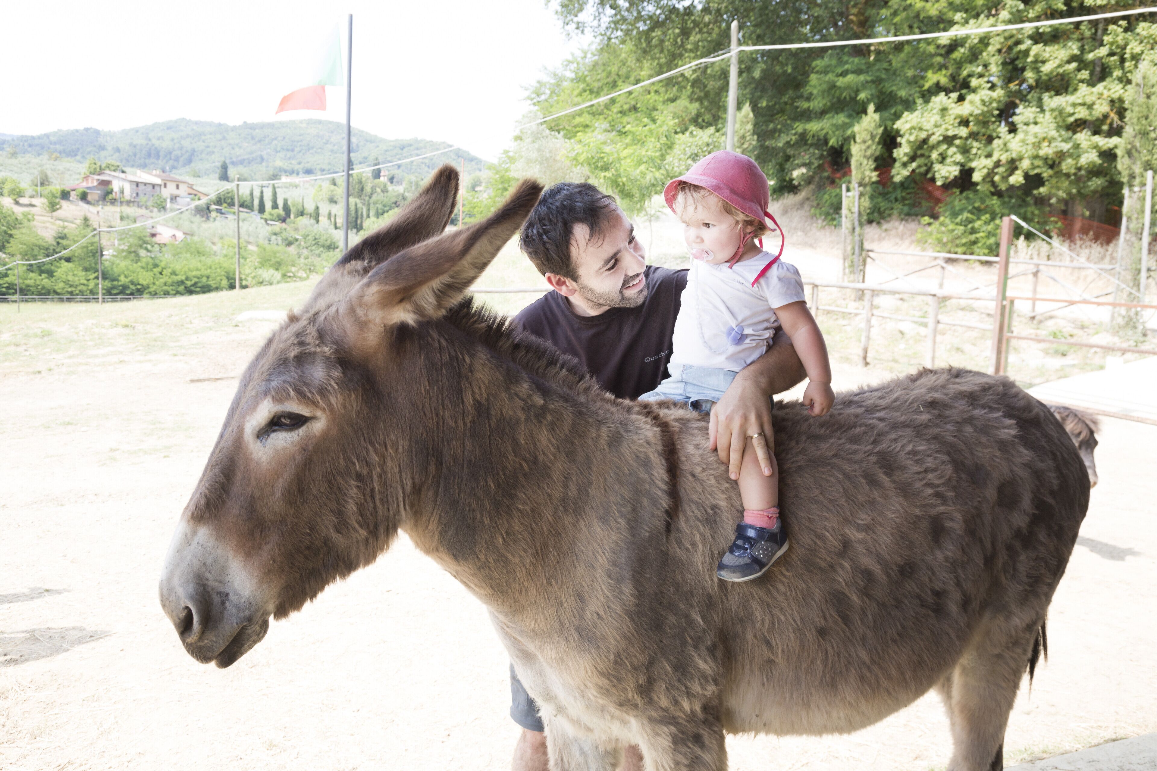 Un hombre y un niño montando un burro.