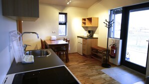 Una cocina compacta con pileta, estufa y armarios de madera.