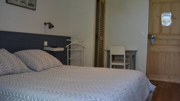 Ein Schlafzimmer mit einem Bett, einem Schreibtisch und einem Stuhl.
