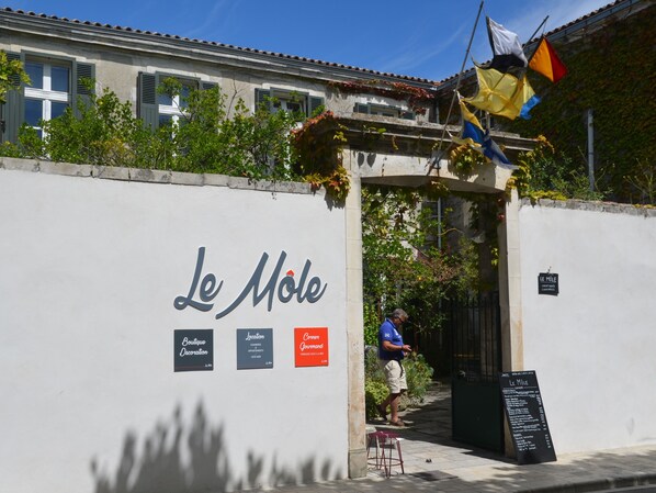 A building with a sign reading "Le Mole" and a signboard listing services like "Boutique Decoration" and "Location". - Le Môle (La Flotte)