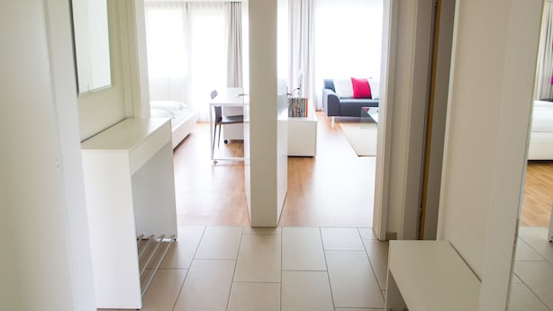 Een moderne hotelkamer met een groot bed, een bureau en uitzicht op de woonruimte.