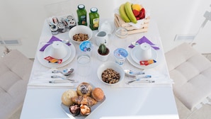Una mesa de desayuno con diversos alimentos, bebidas y utensilios.