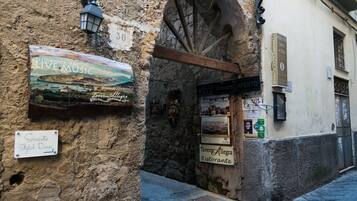 Un mur de pierres rustiques sur lequel on peut lire une enseigne indiquant « Sorrento Stylish Rooms » et une autre indiquant « Ristorante Allegra ».