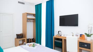 Une chambre d’hôtel comprenant un lit, un bureau, une chaise, une télévision et une armoire.