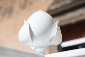Un objet sculptural blanc, orné et raffiné, à la surface lisse, qui pourrait être un élément décoratif ou un élément architectural.