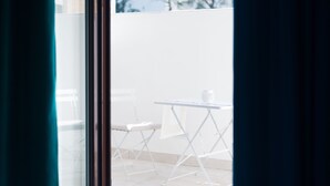 Vista por una ventana con una mesa y una silla afuera.