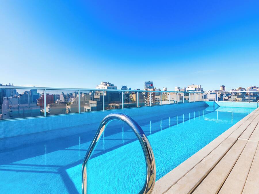 Una piscina en la azotea con vistas despejadas al horizonte de la ciudad.