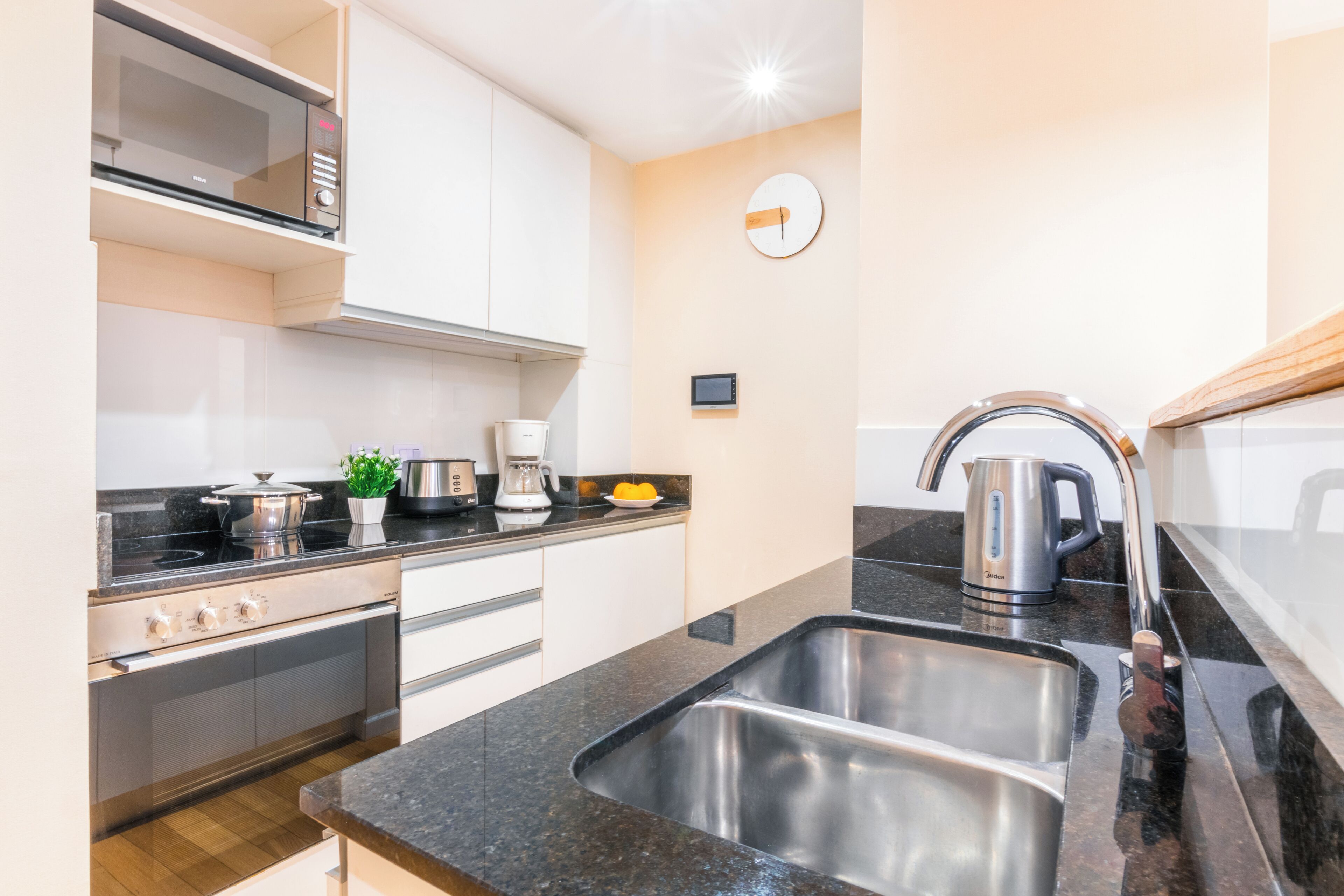 A modern kitchen with stainless steel appliances, a double sink, and a microwave.