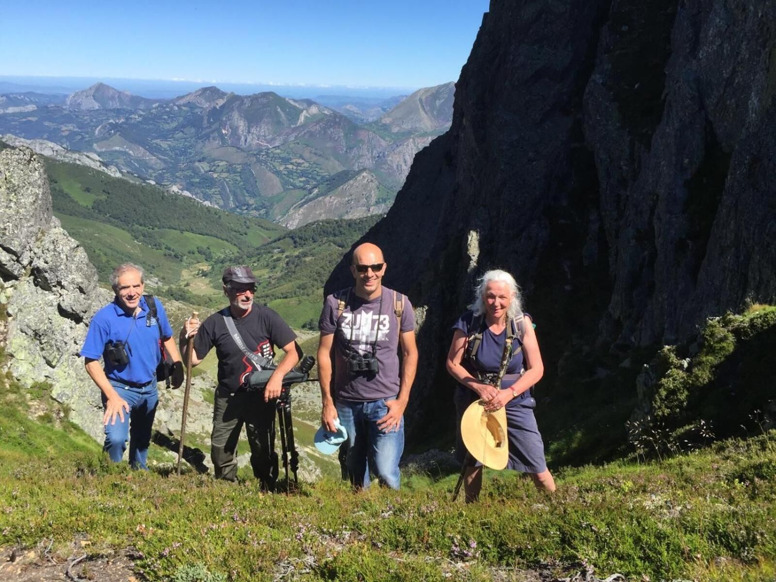 Un groupe de randonneurs sur un sentier de montagne, avec vue sur la vallée en contrebas.