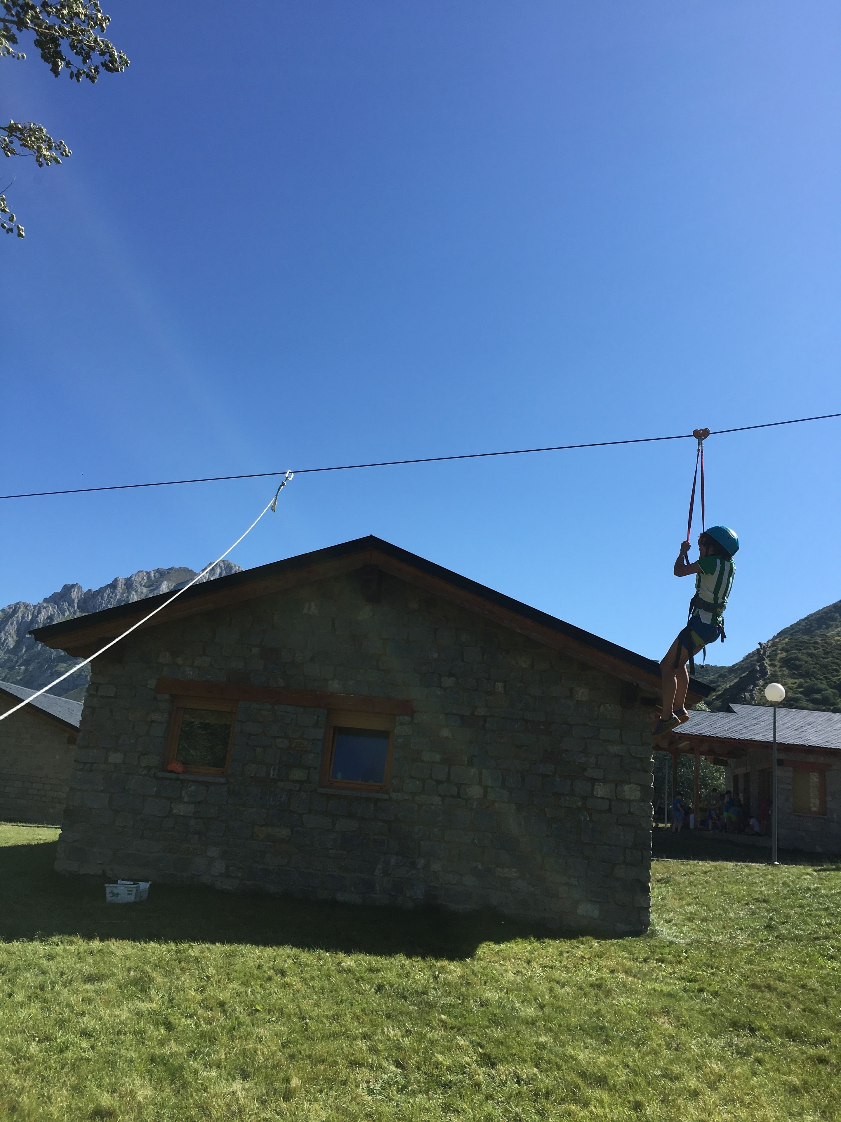 Un edificio in pietra con tetto spiovente, una finestra e un piccolo portico.