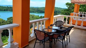 Un balcon avec vue sur un lac et une forêt.