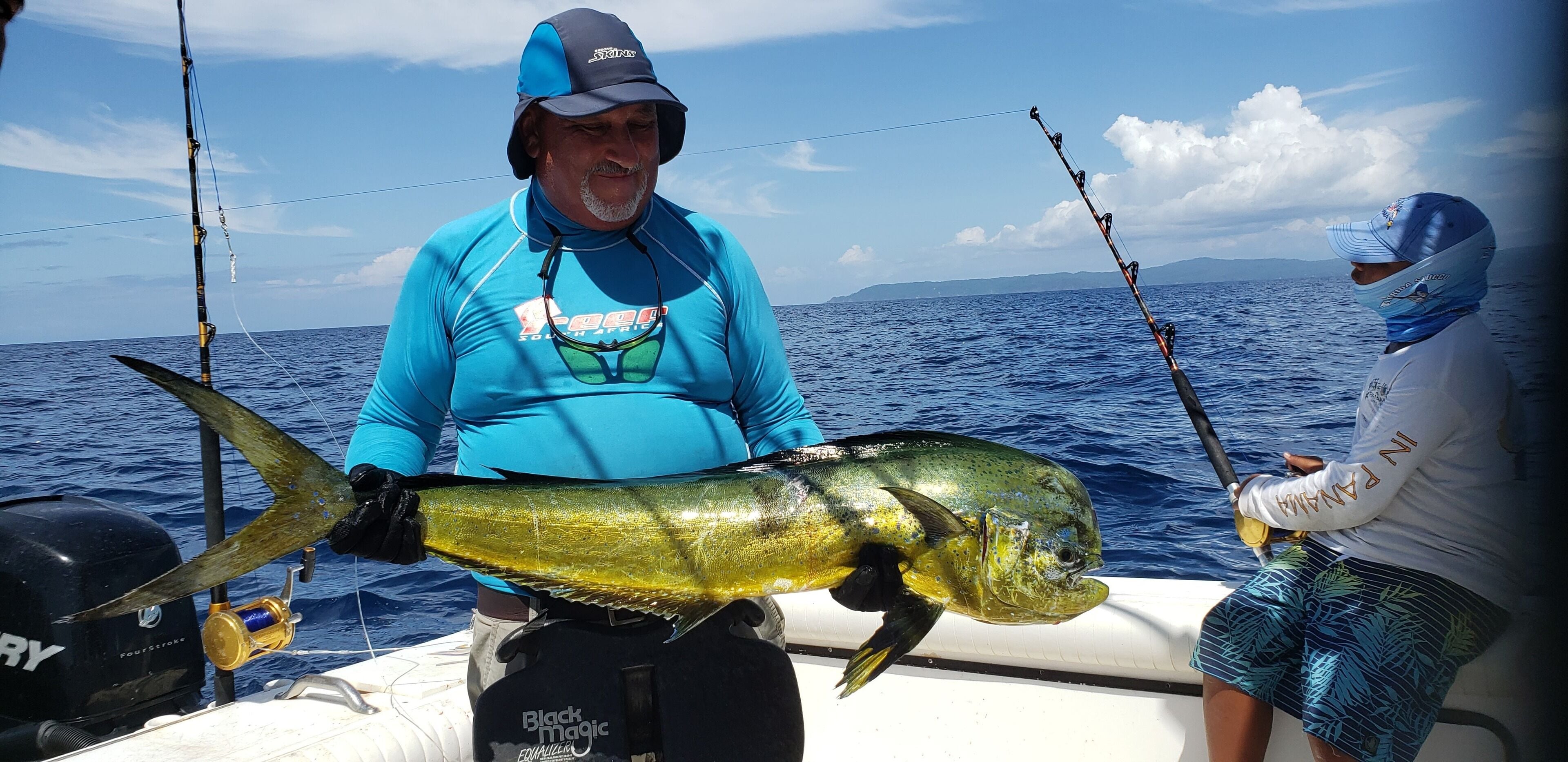 A person holding a large fish on a boat.