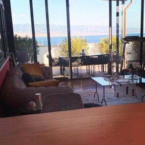 Un salon moderne doté d’une grande fenêtre, d’un canapé, d’une table basse et d’un coin repas.