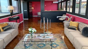 Un salon moderne avec deux canapés, une table basse en verre et un tapis à motifs.