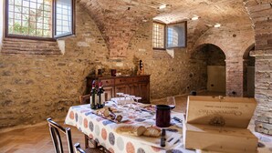 Un comedor rústico con techo de ladrillo, paredes de piedra y una mesa lista para una comida.
