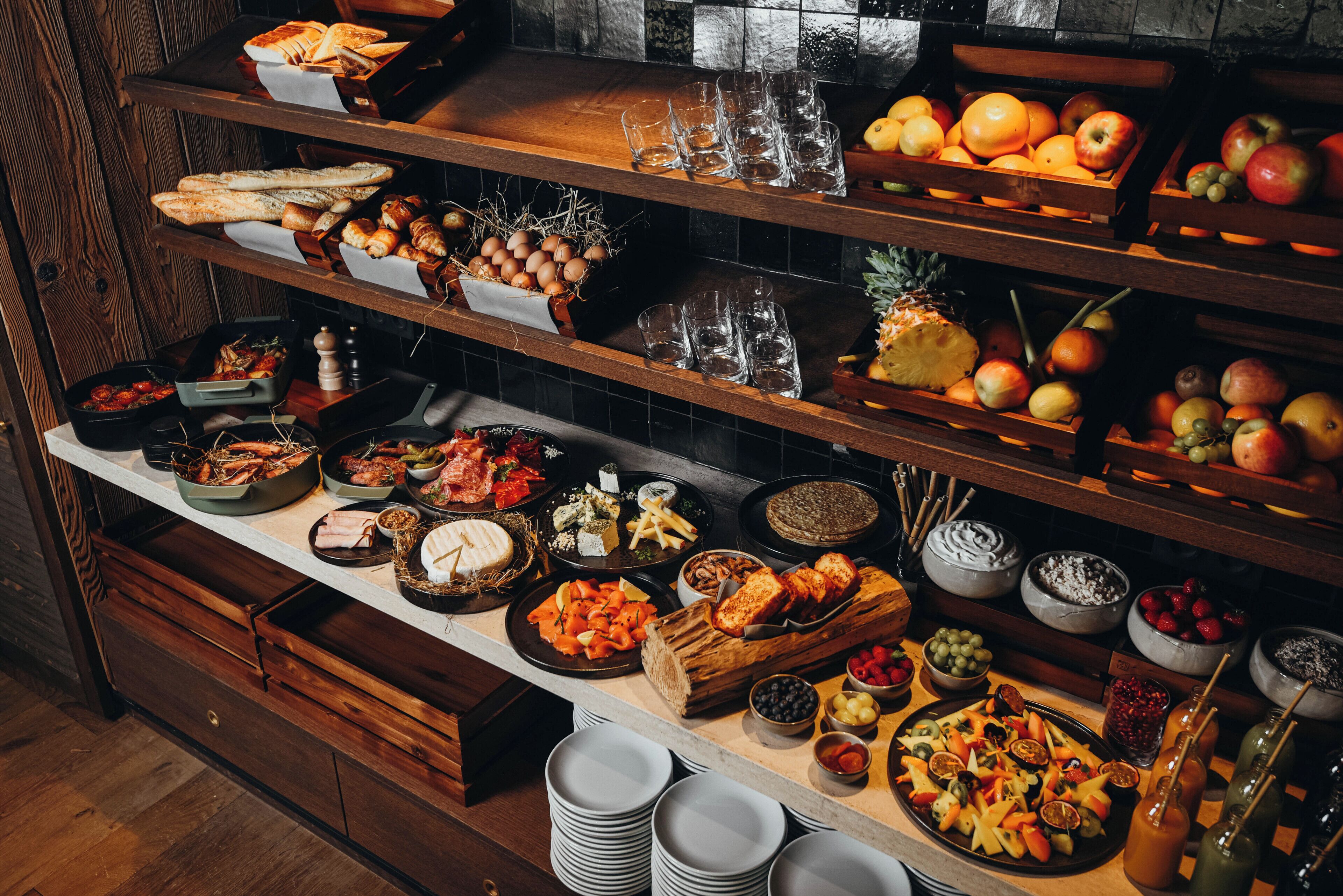 A buffet with various food items and glassware.