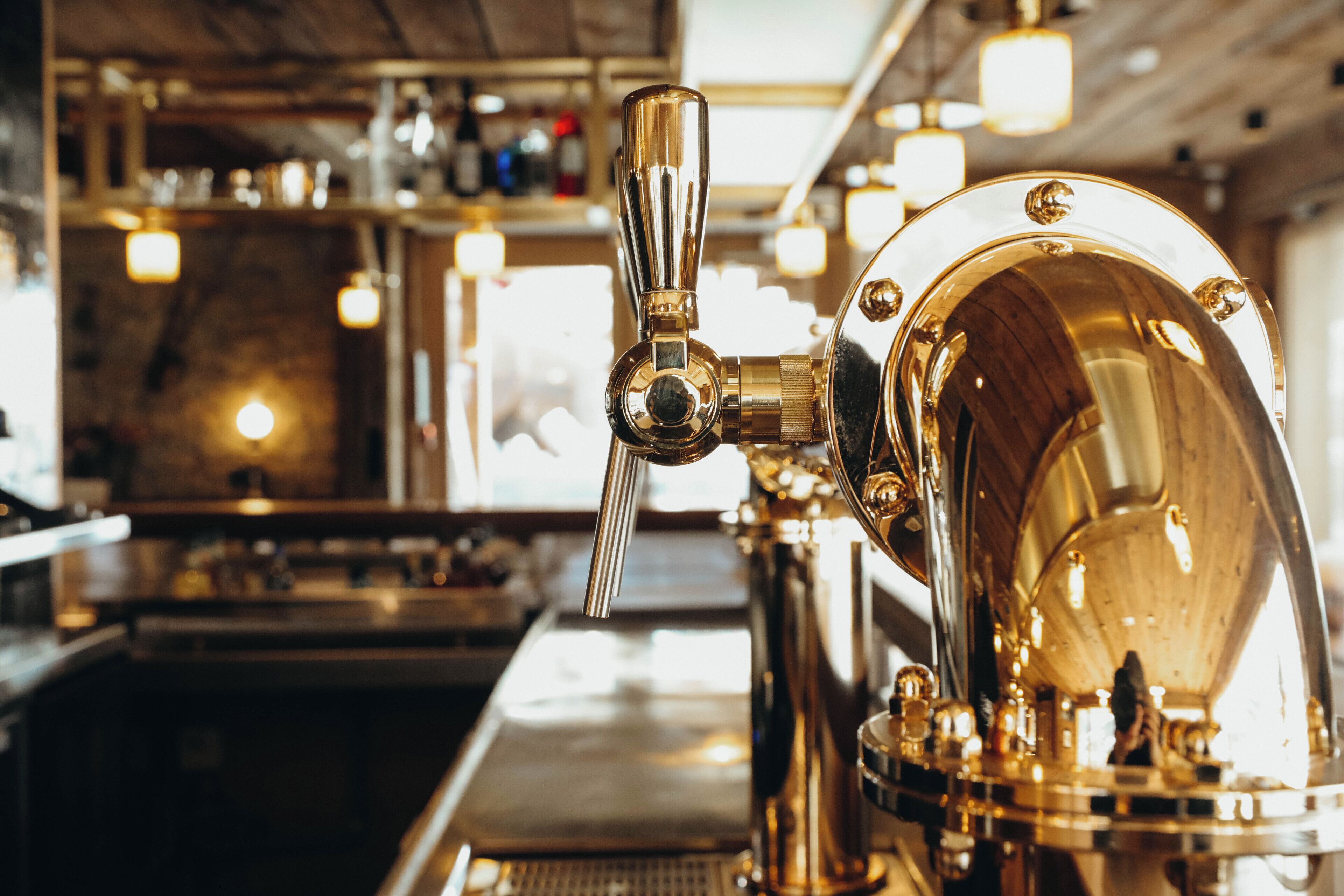 A close-up of a barista preparing coffee with a shiny, metallic espresso machine.
