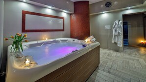 A modern spa room with a large bathtub, a mirror, and a clock on the wall. - Grand Podhale Resort & Spa (Zakopane)