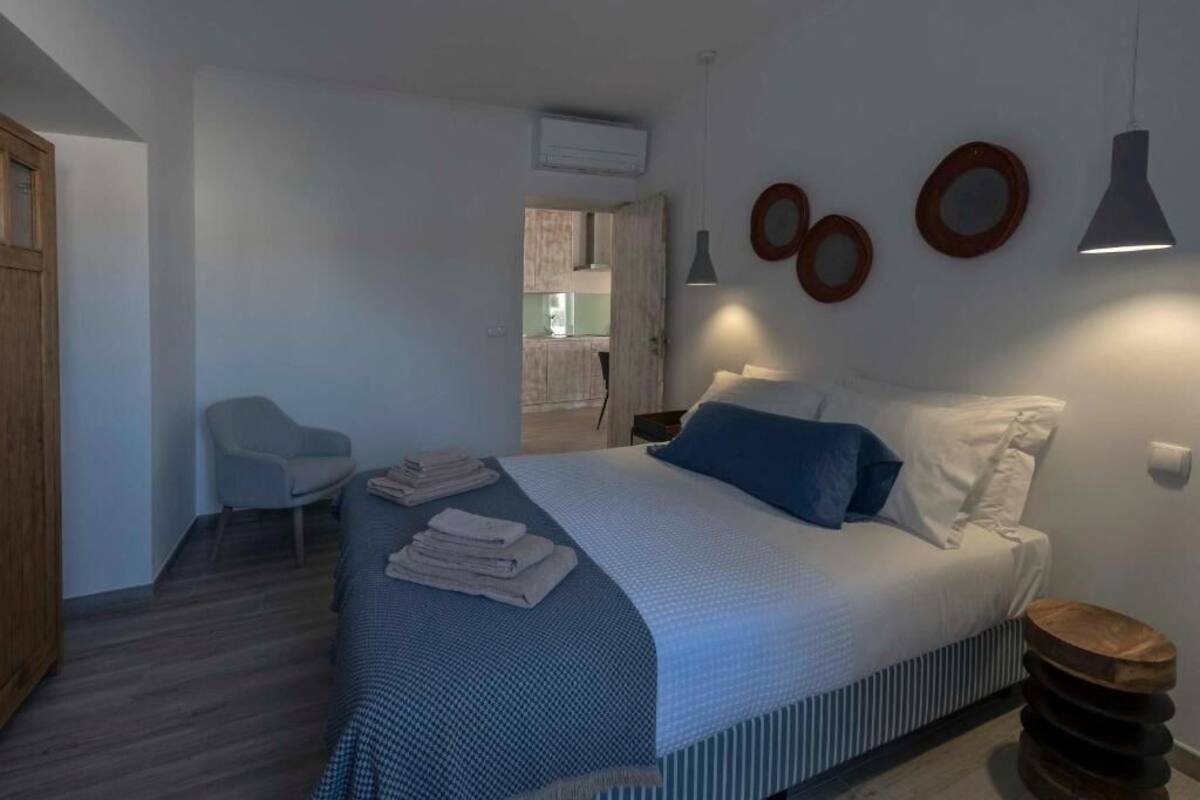 Ein modernes Schlafzimmer mit einem Bett, einem Sessel und einem kleinen Tisch.