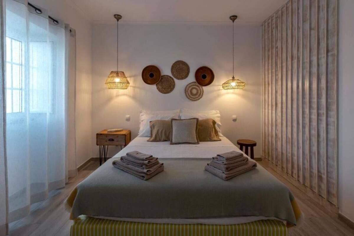 Ein modernes Schlafzimmer mit einem großen Bett, Nachttischen und dekorativer Wandgestaltung.