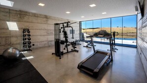 A modern gym with a treadmill, weight machines, and a large exercise ball. - Monte Vale Organic Farm (Castro Verde)