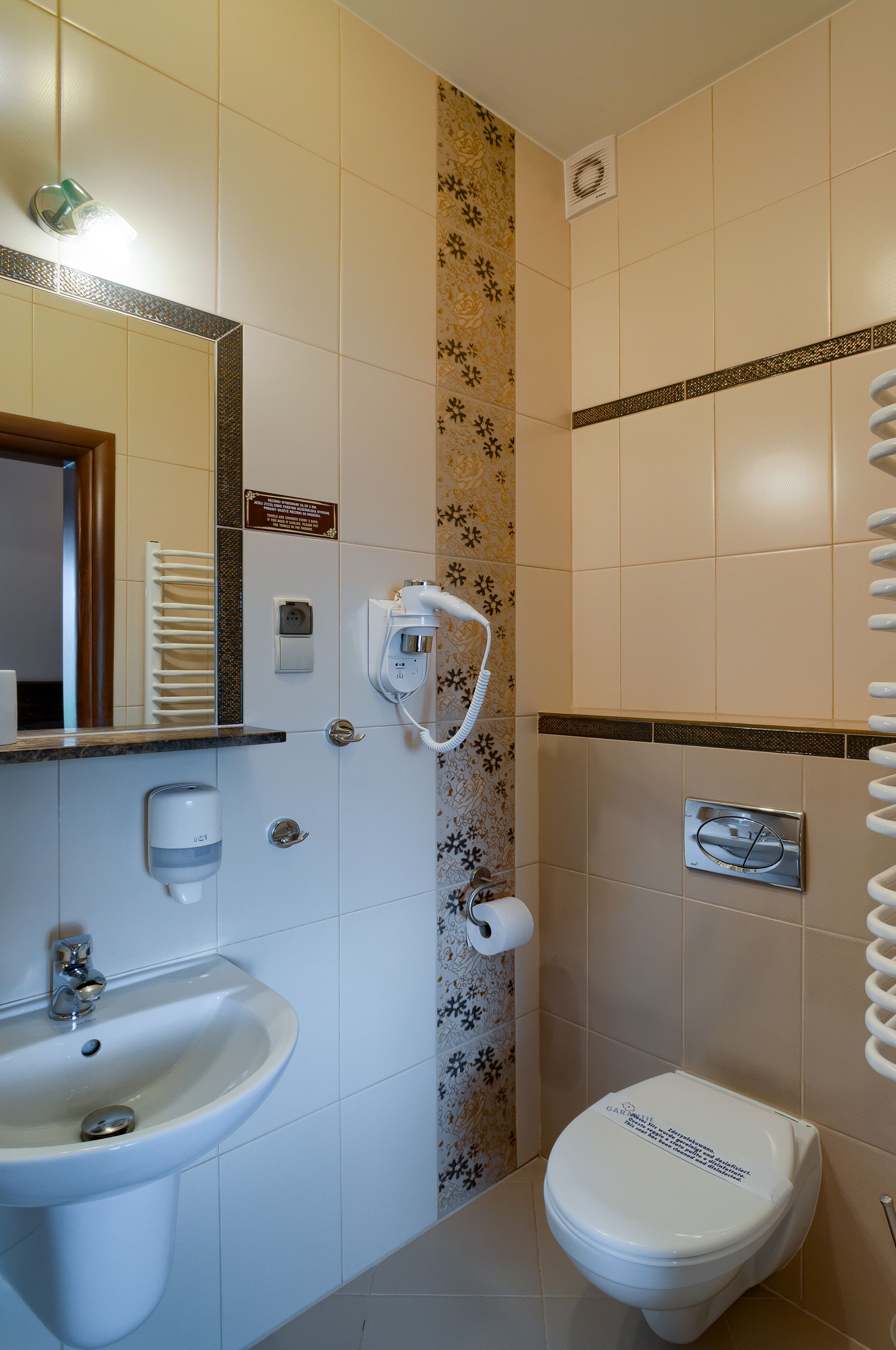 A bathroom with a sink, toilet, and a towel rack.