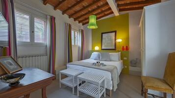 A bedroom with a wooden ceiling, a bed with white bedding, a bedside table with a bowl, and a chair.