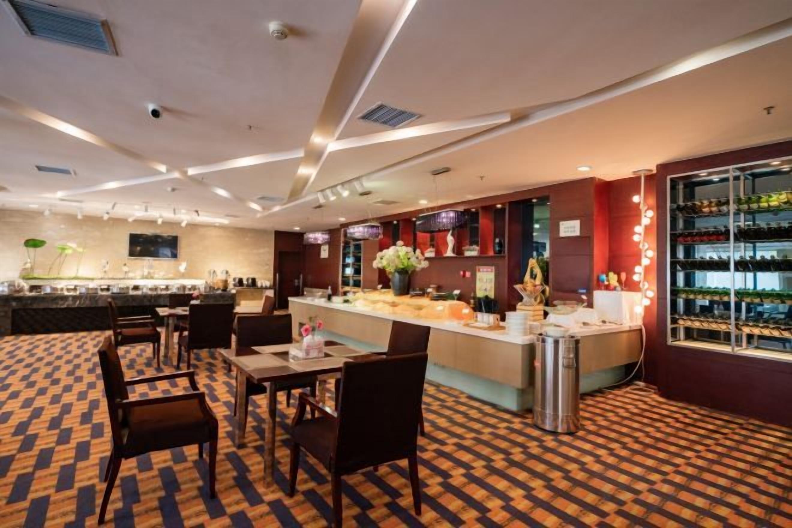 Et hotel lobby med barområde, siddepladser og et gulvtæppe med et mønster.
