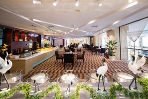 A spacious hotel lobby with a check-in counter, dining area, and seating arrangements. - Linhai International Hotel (Funing)
