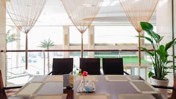 A conference room with a long table, chairs, and a potted plant.