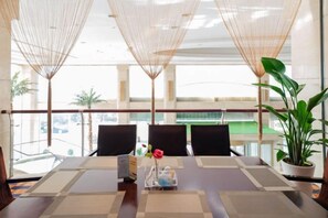 A conference room with a long table, chairs, and a potted plant. - Linhai International Hotel (Funing)