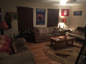 Relax in a cozy living room with a comfortable sofa, coffee table, and plush rug.