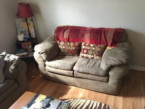 Relax in this inviting living room with a leather sofa, coffee table, and warm wooden floor.