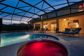 A swimming pool with lounge chairs and a glass ceiling structure.