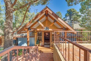 A wooden cabin with a brick porch, a staircase, and a metal railing. - 2 Mi to Village of Ruidoso! 'Little Pine Cottage' (Ruidoso)