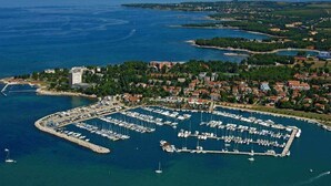 An aerial view of a marina with numerous boats docked, surrounded by residential buildings and greenery. - Villa DANEX SUPERIOR 2 **** (Umag)
