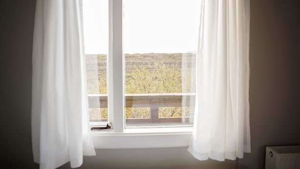 A room with a window overlooking a barren landscape. - Hestaland Riverside Cottage (Borgarbyggd)