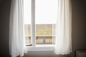 Una habitación con ventana que da a un paisaje árido.