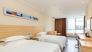 A hotel room with two beds, a desk, a chair, a coffee maker, and a window with curtains. - City Comfort Inn (Guangzhou)