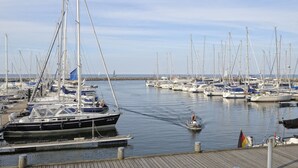 Een jachthaven met verschillende zeilboten die aan houten steigers liggen.