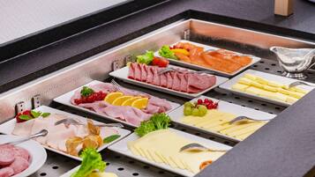 A buffet with various food items including meats, cheeses, and fruits.
