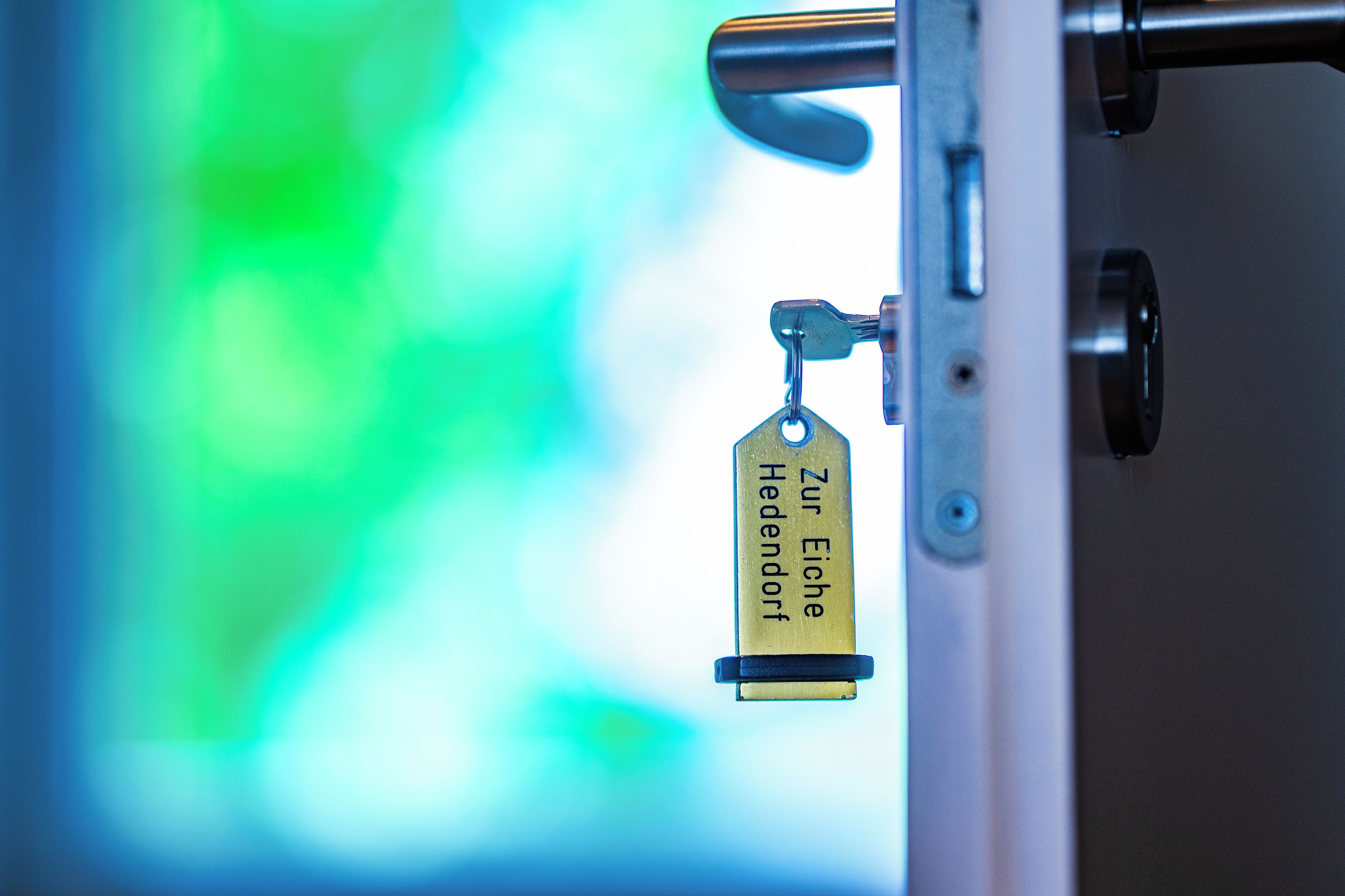 A metal door handle with a keyhole and a keychain with a tag.