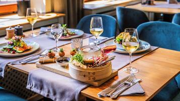 Un restaurant avec des tables, des chaises et une variété de plats et de boissons proposés.