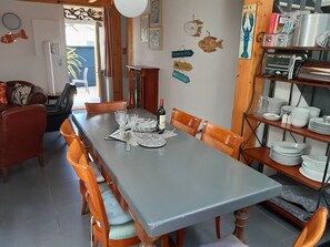 Ein Essbereich mit einem langen Tisch, gedeckt für sechs Personen, umgeben von Holzstühlen.