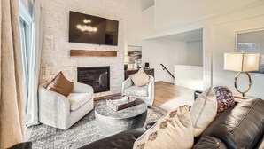 A modern living room with a fireplace, two sofas, a coffee table, and a lamp. - Free SkyCard Act 2-Level Condo + Loft, Outdoor Pool/Hot Tubs-Lances West 7 (Breckenridge)